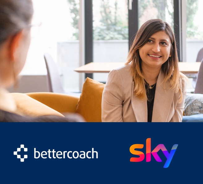 woman in a blazer laughing and listening to someone